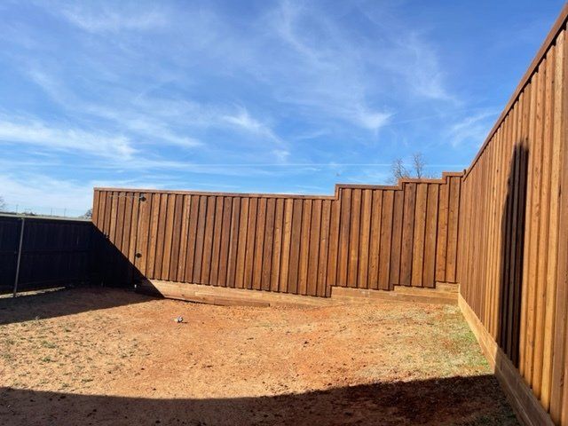 A wooden fence with a blue sky in the background