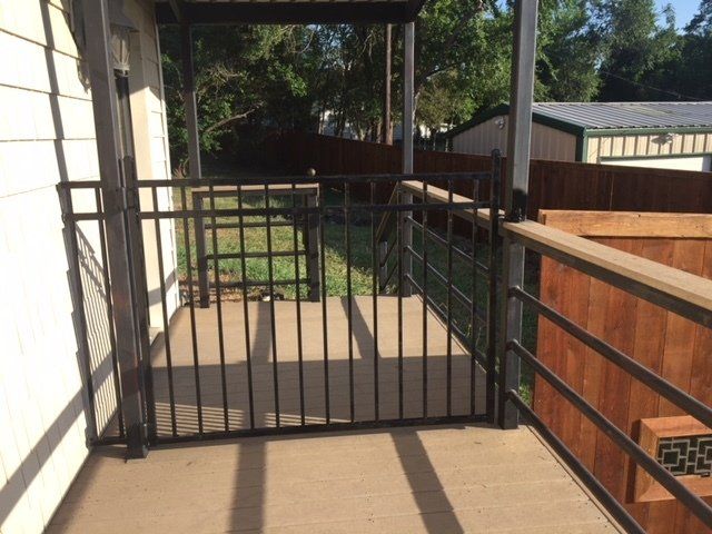 A balcony with a metal fence and a wooden railing