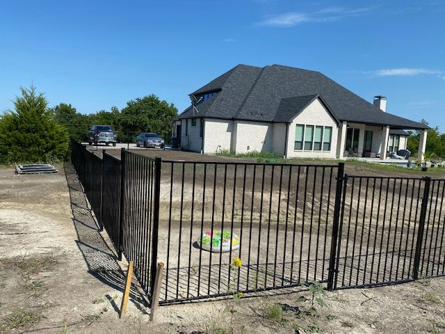 A white house with a black fence in front of it