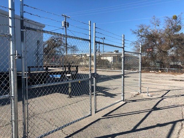 A chain link fence with barbed wire surrounding it