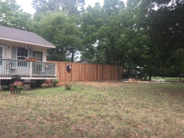 A house with a wooden fence in front of it.