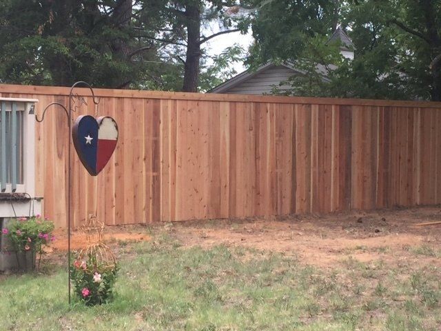 A wooden fence with a heart in front of it.