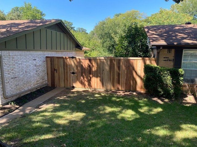There is a wooden fence in front of a house.
