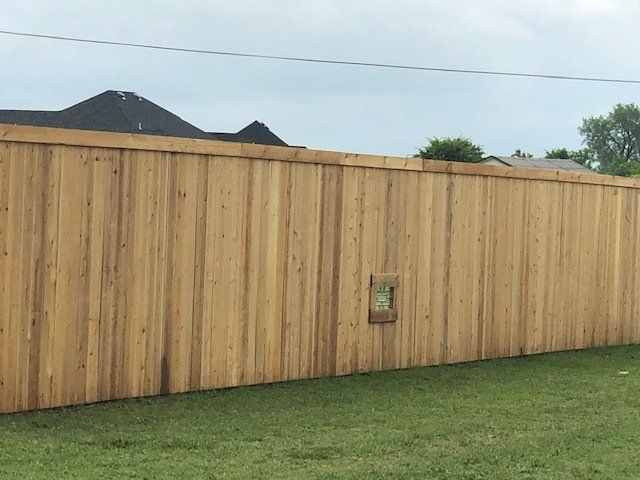 A wooden fence is sitting on top of a lush green lawn.