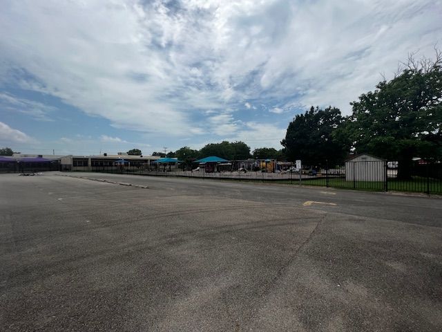 An empty parking lot with a building in the background