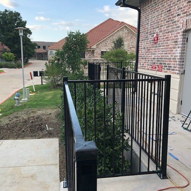 A brick house with a black railing in front of it
