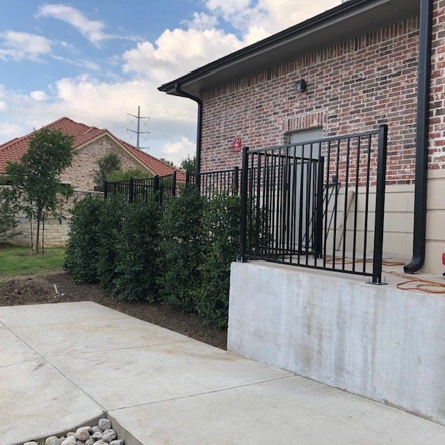A brick house with a black fence around it