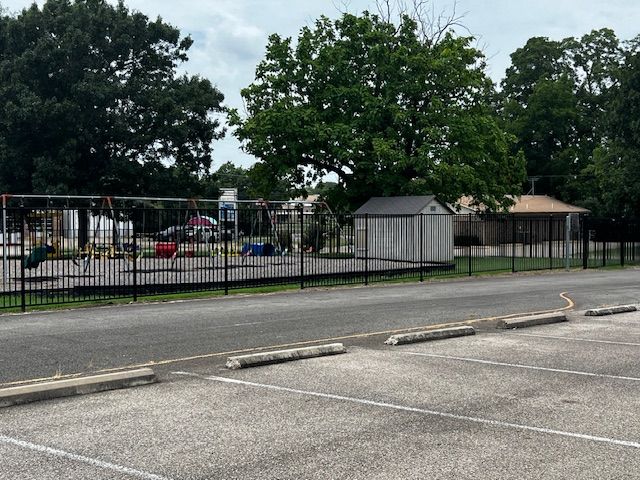 A parking lot with a playground in the background