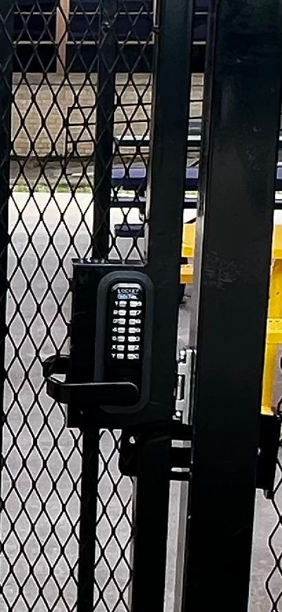 A close up of a gate with a keypad on it.