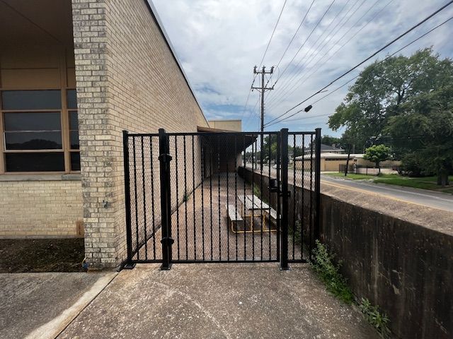 A brick building with a picnic table behind a gate