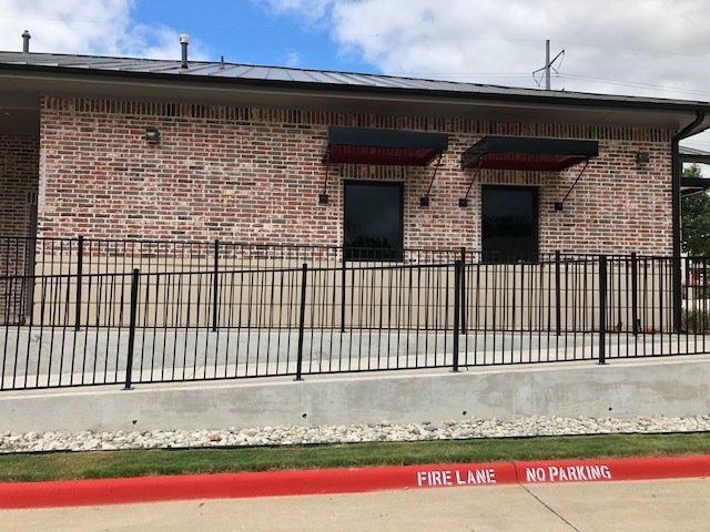 A brick building with a metal fence around it.