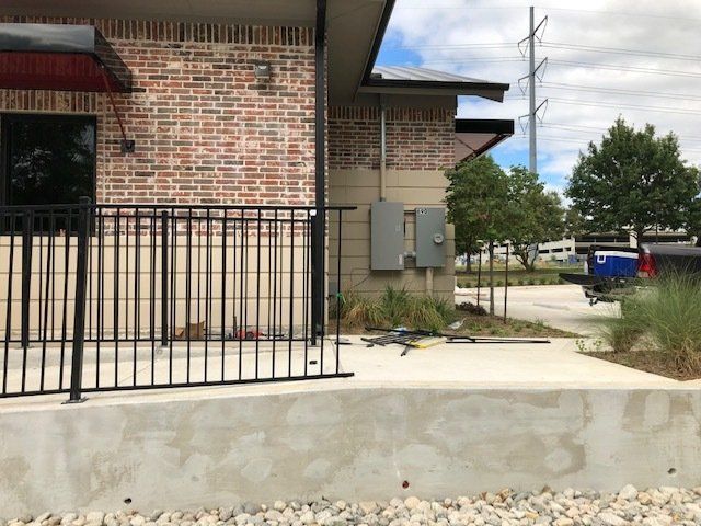 A brick building with a metal railing in front of it