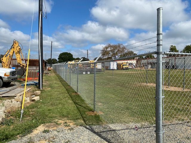 A chain link fence is surrounding a construction site.