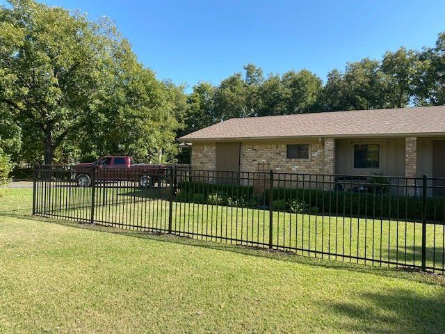 A house with a fence around it and a truck parked in front of it.