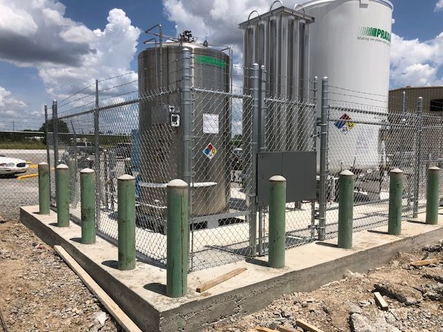 A chain link fence surrounds a chemical plant.