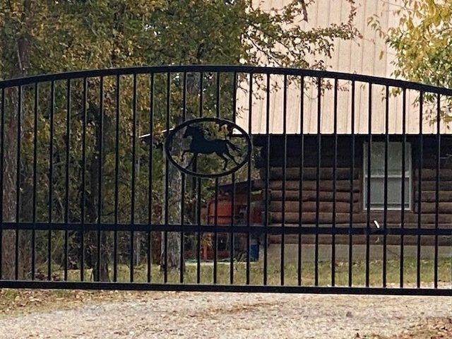 A black gate with a horse in the middle of it