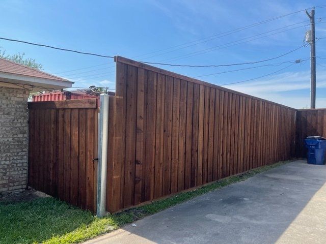 A wooden fence with a gate in the backyard of a house.