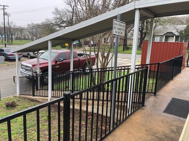 A red truck is parked under a covered walkway.