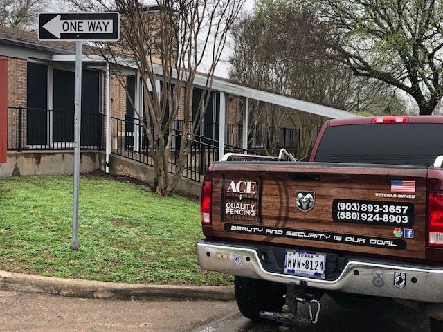 A red truck is parked in front of a one way sign.