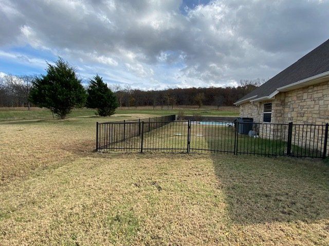 There is a fence in the backyard of a house.