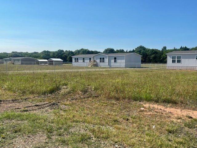 A group of mobile homes are sitting in a grassy field.