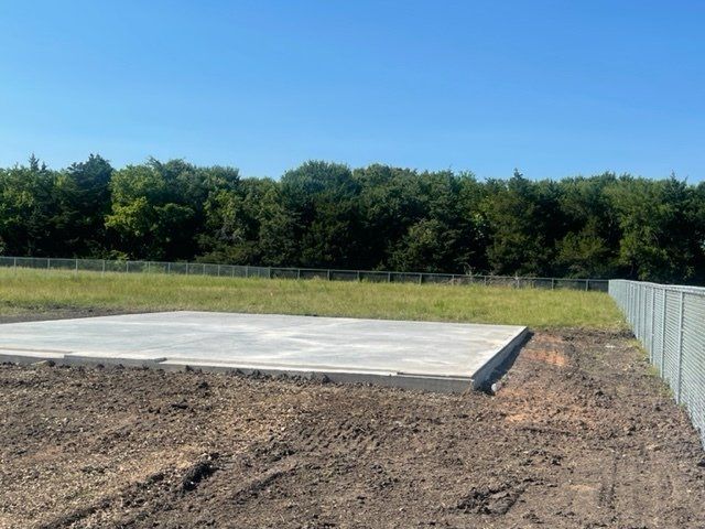 A concrete slab is sitting in the middle of a dirt field.