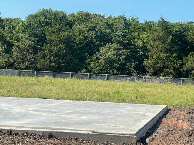A concrete slab is sitting in the middle of a grassy field.