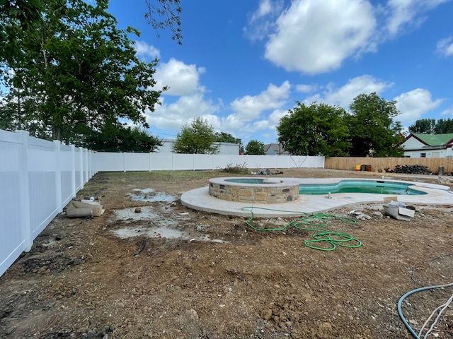 A swimming pool is being built in the backyard of a house.