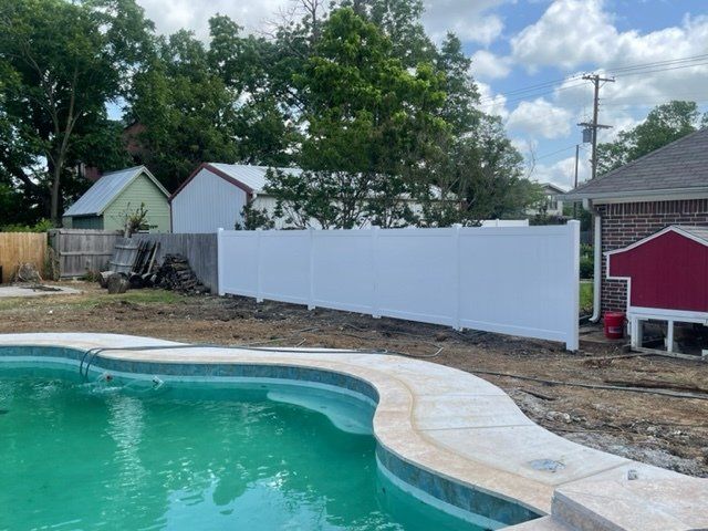 A swimming pool with a white fence surrounding it