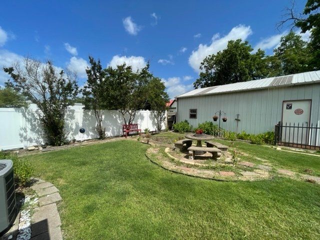 A backyard with a picnic table in the middle of it