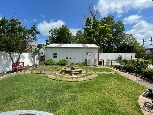 There is a picnic table in the middle of the yard.