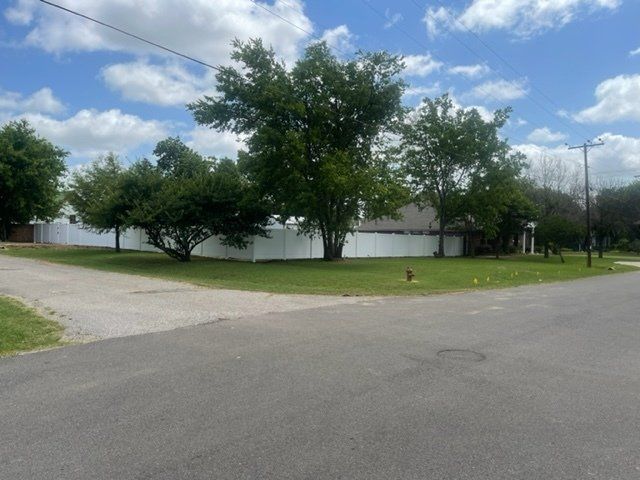 A house with a white fence and trees in front of it