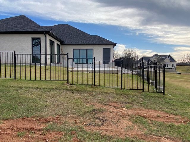 A white house with a black fence in front of it