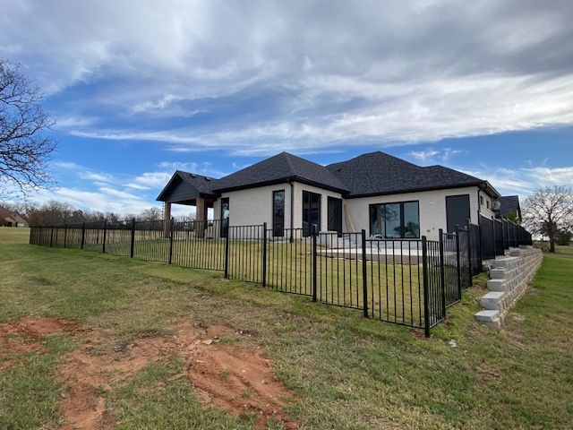 A house with a black fence in front of it.