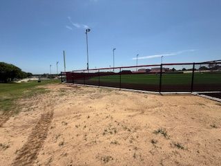 A baseball field with a fence surrounding it