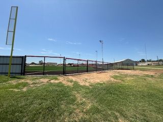 There is a baseball field with a fence around it.