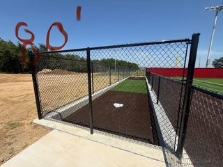 A baseball field with a chain link fence and a base