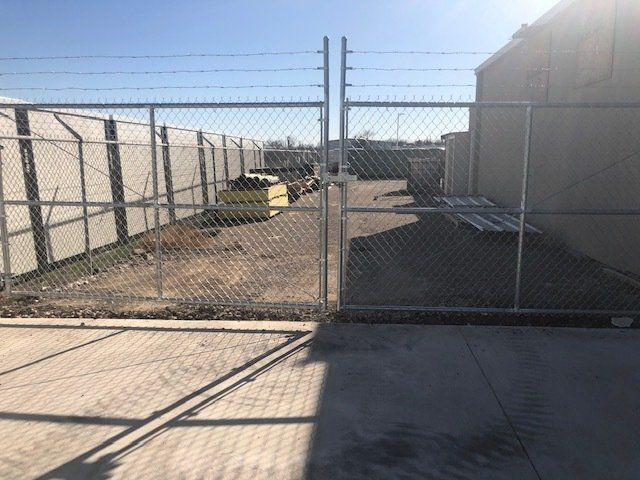 A chain link fence is surrounding a parking lot.