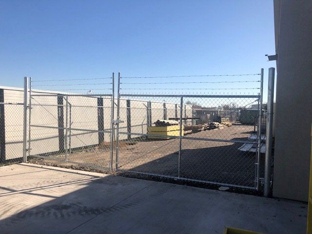 A chain link fence with barbed wire surrounding it