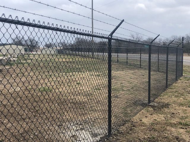 A chain link fence with barbed wire on top of it