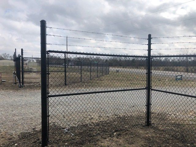 A chain link fence with barbed wire surrounding it.
