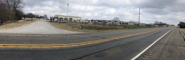 A panoramic view of a highway with a building in the background.