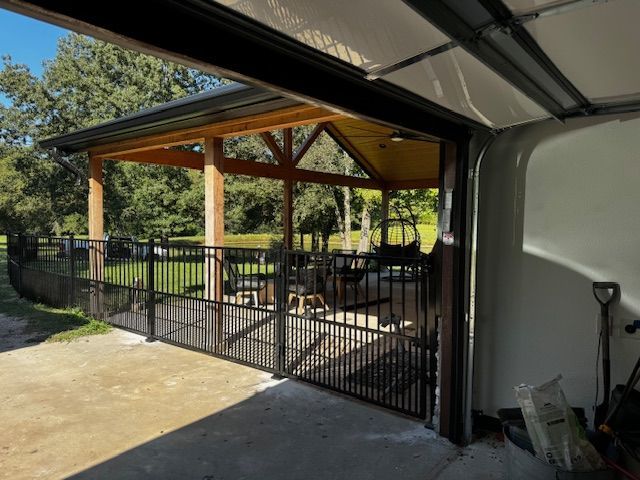 A garage with the door open and a fence around it
