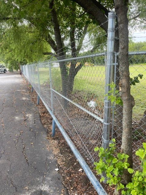 A chain link fence along the side of a road