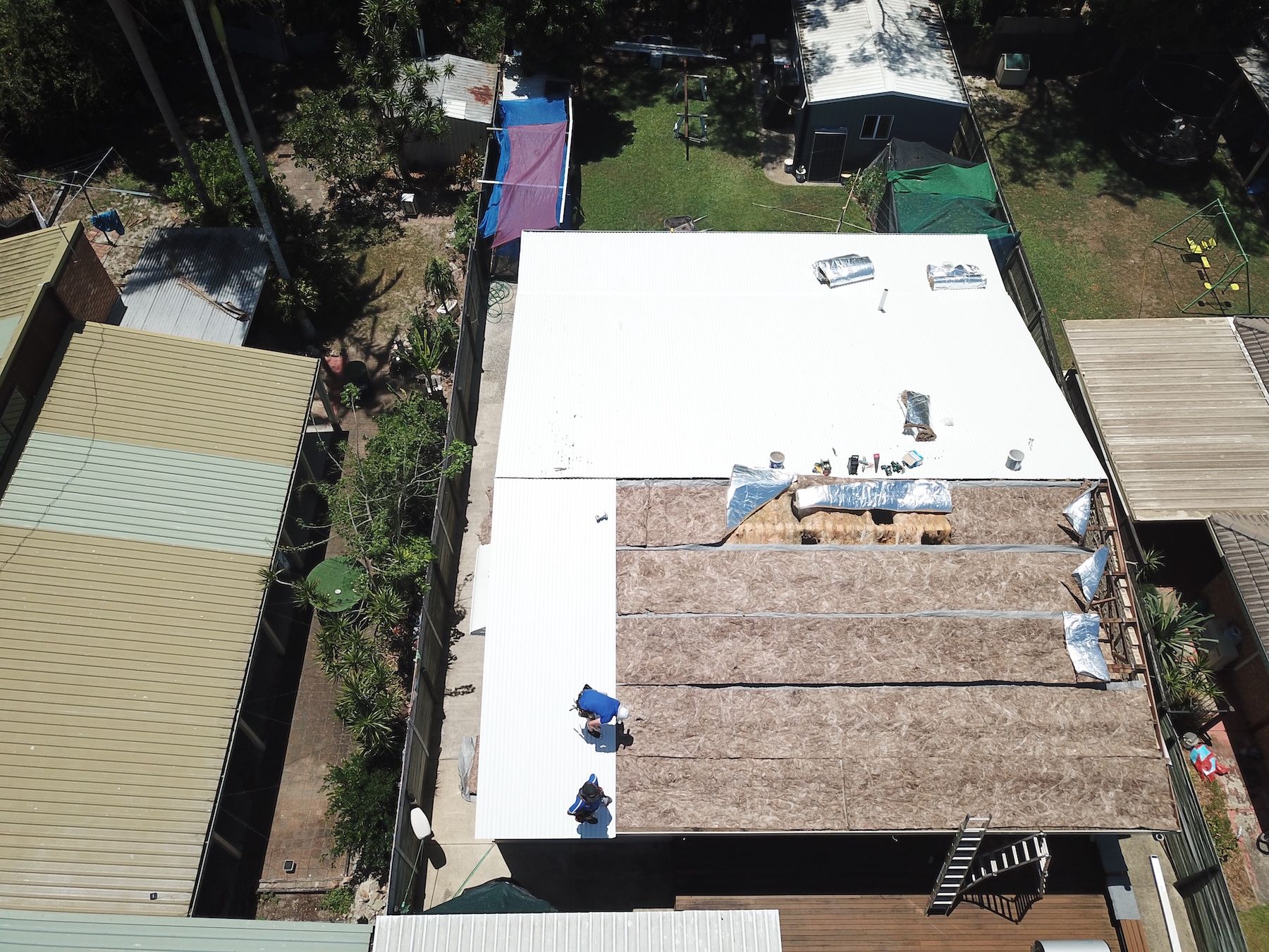 A Man Is Painting The Side Of A House — Coastal Roof & Gutter Services In Coolum Beach, QLD