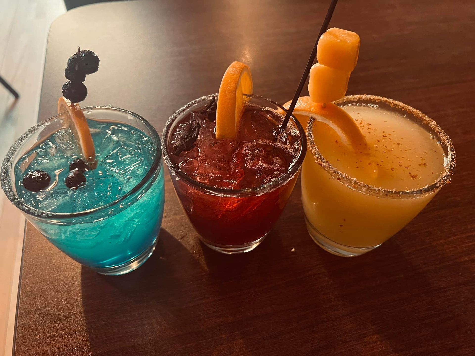 Three different colored drinks are sitting on a table.