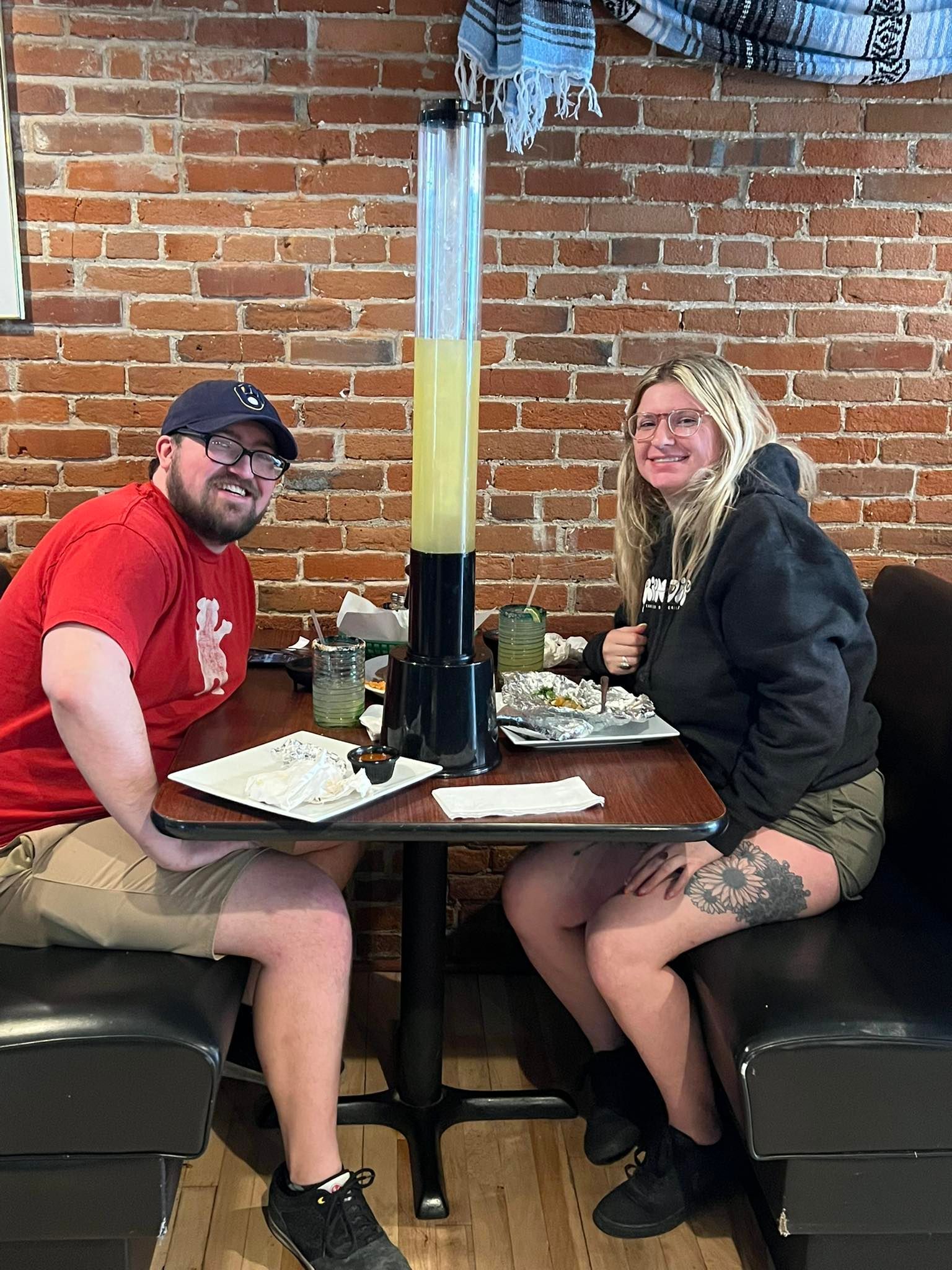 A man and a woman are sitting at a table in a restaurant.