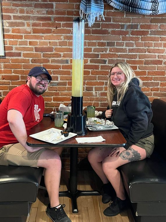 A man and a woman are sitting at a table in a restaurant.