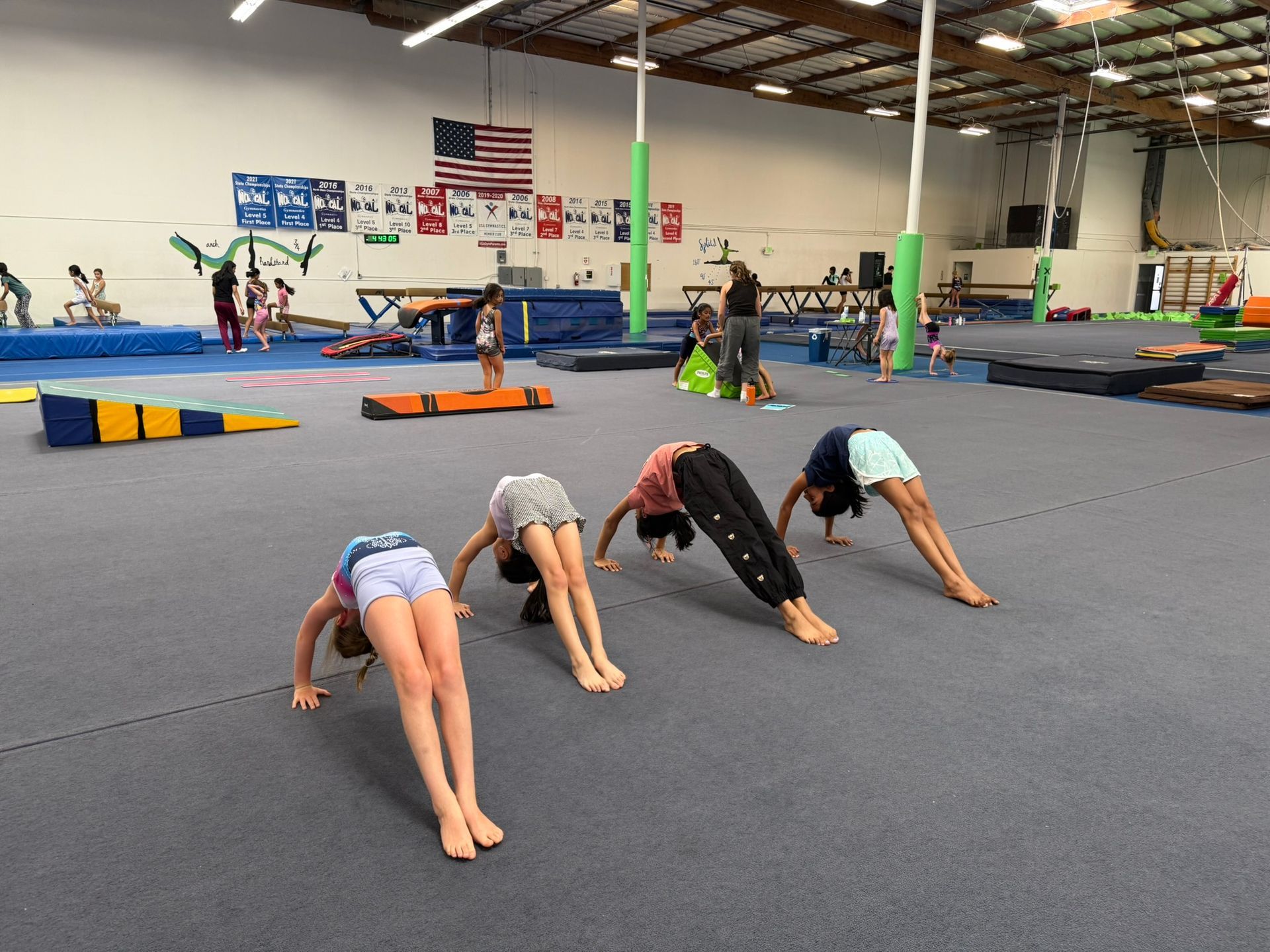 A group of young girls are doing exercises in a gym.