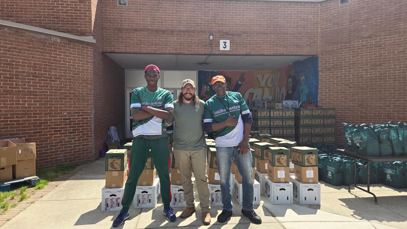 Three men are posing for a picture in front of a brick building.